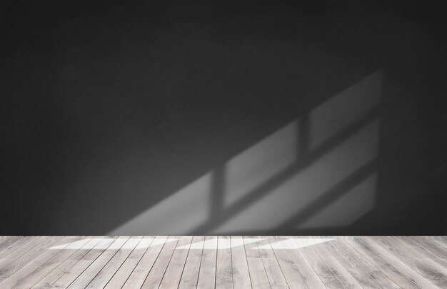 Mur noir dans une pièce vide avec plancher en bois