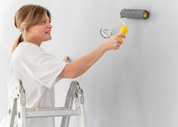 Mur de peinture femme avec rouleau
