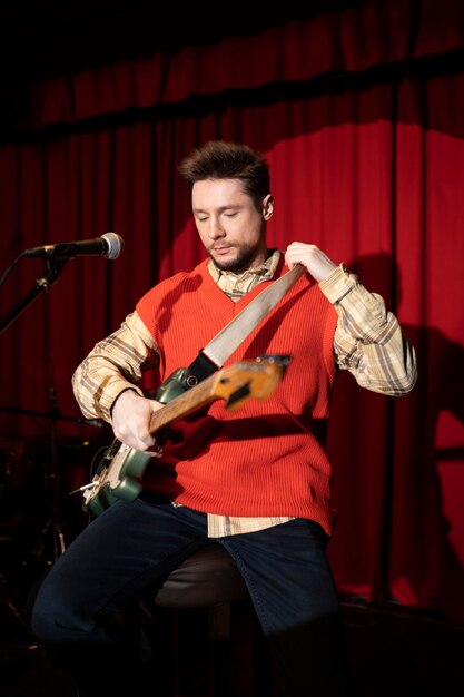 Musicien de coup moyen tenant la guitare