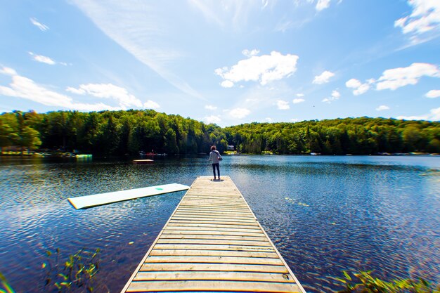 Musicien debout devant le lac sous un ciel ensoleillé