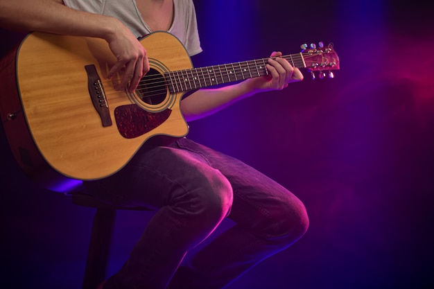 Le musicien joue de la guitare acoustique.