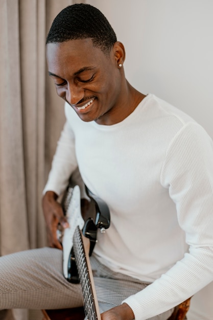 Photo gratuite musicien masculin smiley avec guitare