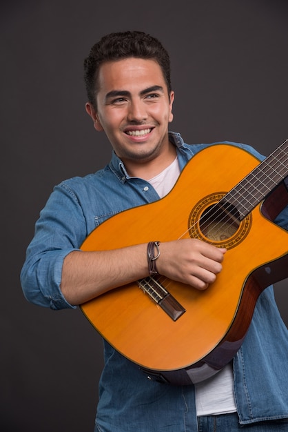 Musicien positif jouant de la guitare sur fond noir