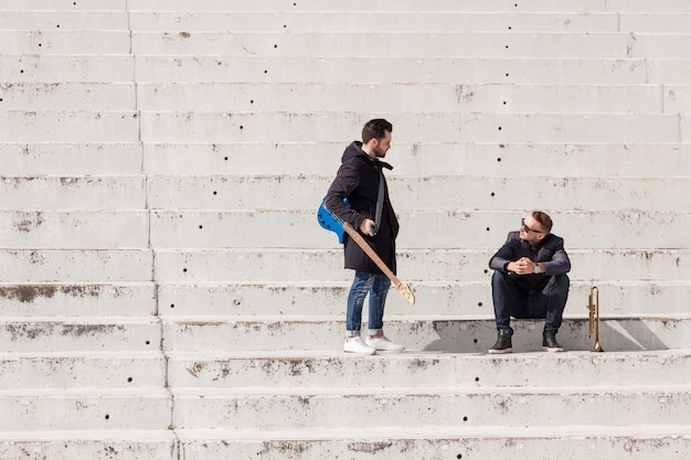 Musiciens parlant sur des escaliers en béton