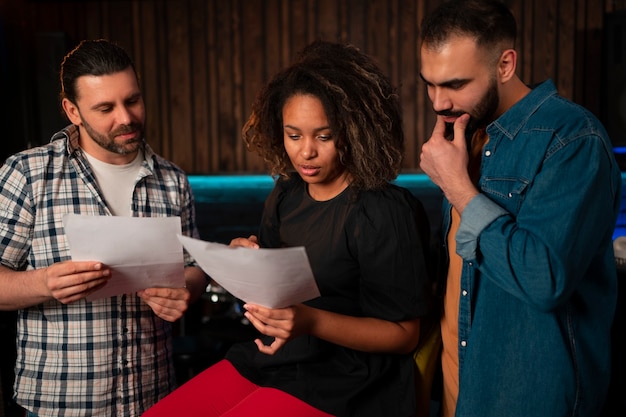 Photo gratuite musiciens de plan moyen travaillant en studio