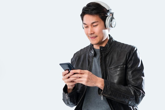 Musique application mobile smartphone technologie conceptbonheur asiatique décontracté homme mûr porter de la musique au casque jouant le geste de la main tenir l'application de liste de lecture smartphone avec joyeux et joyeux