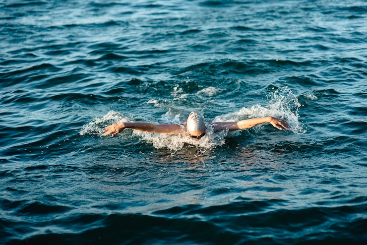 Photo gratuit nageur avec casque et lunettes de protection nageant dans l'eau