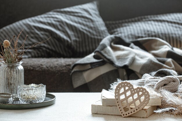 Nature morte avec un cœur décoratif, des livres et des choses douillettes pour la maison. Le concept de la Saint-Valentin et du confort à la maison.