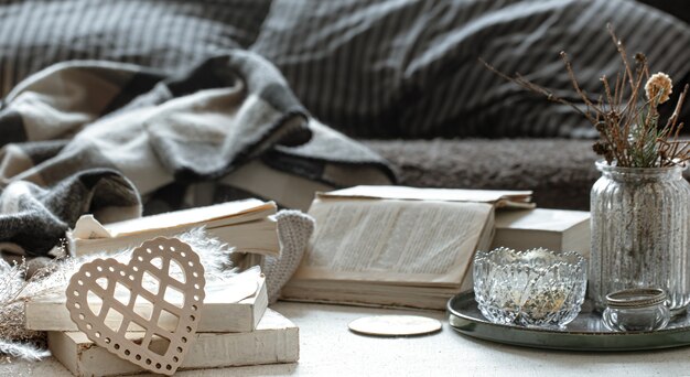 Nature morte avec un cœur décoratif, des livres et des choses douillettes pour la maison.