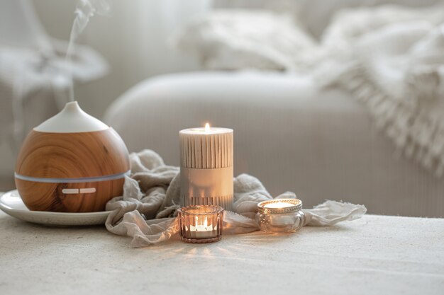 Nature morte avec diffuseur d'arômes pour humidifier l'air et bougies allumées.