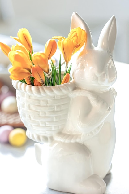 Photo gratuite nature morte de pâques avec des oeufs de lièvre en céramique et des fleurs