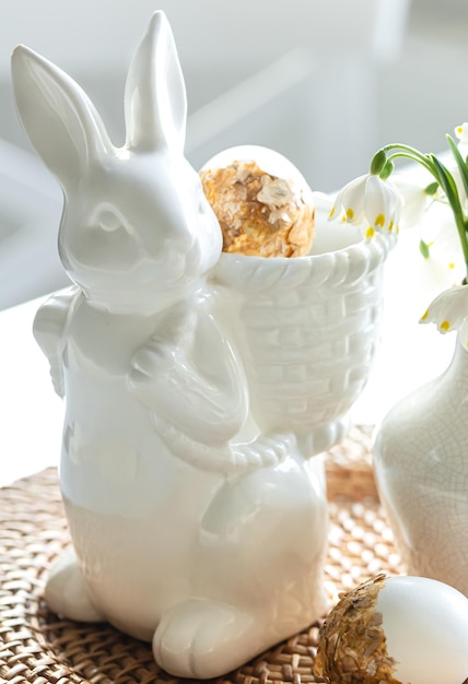 Photo gratuite nature morte de pâques avec des oeufs de lièvre en céramique et des fleurs