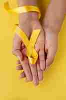 Photo gratuite nature morte de ruban jaune à la main