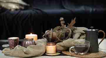 Photo gratuite nature morte sur la table avec des bougies, un livre de chandail et des feuilles d'automne. salon confortable, décoration intérieure à la maison.