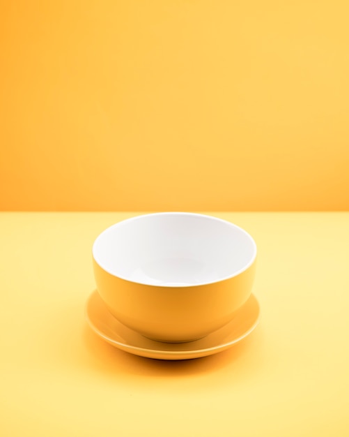 Photo gratuite nature morte de tasse jaune