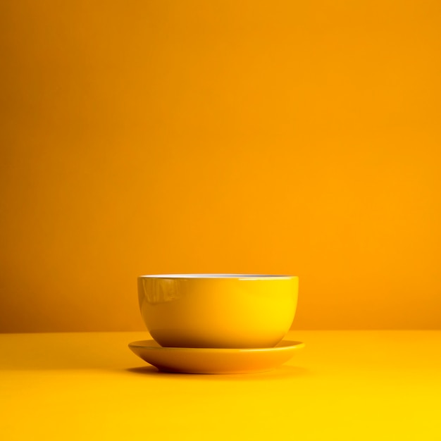 Photo gratuite nature morte de tasse jaune