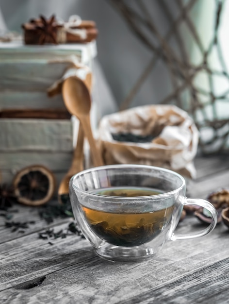 Nature morte avec tasse de thé transparent sur fond de bois