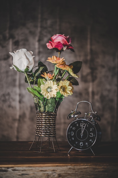 Photo gratuite nature morte avec vases à fleurs et horloges