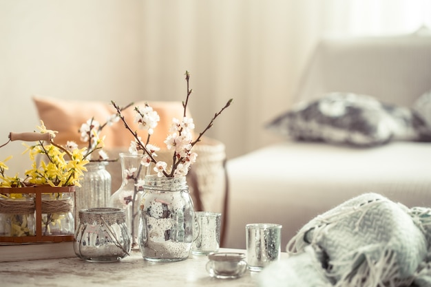 Photo gratuite nature morte avec des vases avec des fleurs de printemps dans le salon