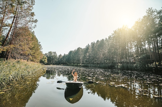 Photo gratuite nautique. une femme assise dans un bateau et ramant