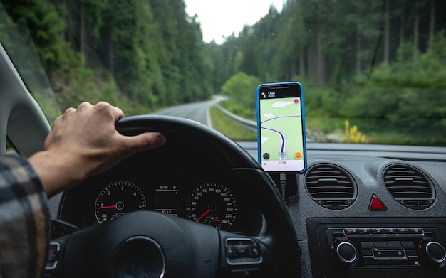 Photo gratuite navigateur dans la voiture sur la route dans un gros plan de zone forestière