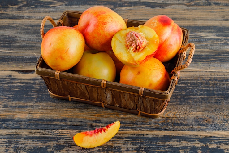 Photo gratuit nectarines dans un panier sur table en bois, vue grand angle.