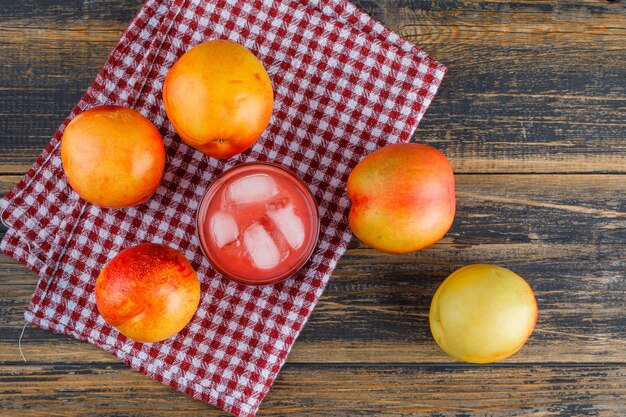 Nectarines avec du jus plat poser sur une serviette en bois et de cuisine