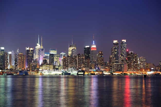 New York City Manhattan Midtown skyline at night avec réflexion des lumières sur la rivière Hudson vue du front de mer de New Jersey Weehawken.