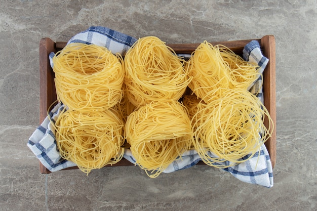 Nids De Spaghettis Crus Dans Une Boîte En Bois.