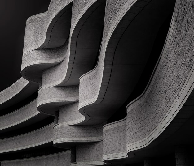 Niveaux de gris à faible angle d'un bâtiment à l'architecture brutaliste moderne sous la lumière du soleil