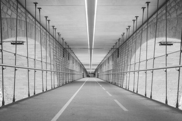 Niveaux de gris d'un tunnel entouré de lumières pendant la journée