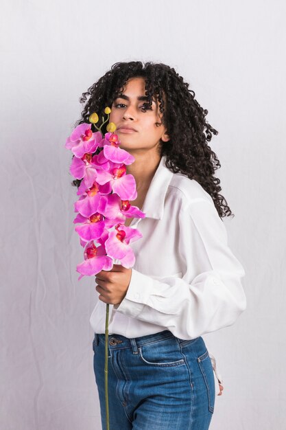 Noir jeune femme tenant une fleur rose