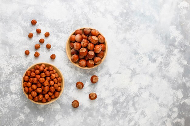 Noisette avec noisettes pelées dans une petite assiette sur du béton, vue de dessus.