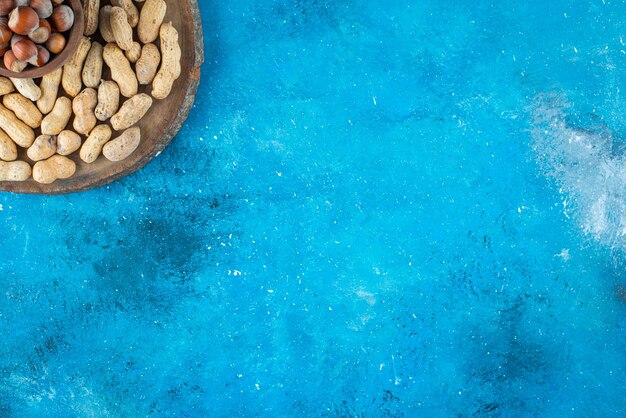 Noisettes Dans Un Bol à Bord Avec Des Cacahuètes , Sur La Table Bleue.