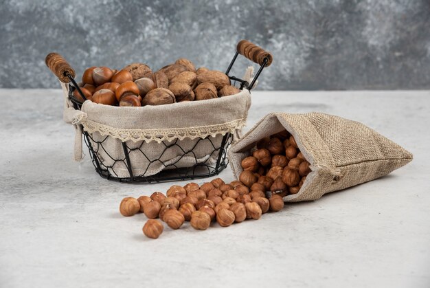 Noisettes et noix décortiquées biologiques dans un panier avec un sac de noyaux.