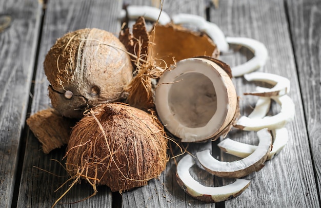 Noix de coco cassées fraîches sur table en bois