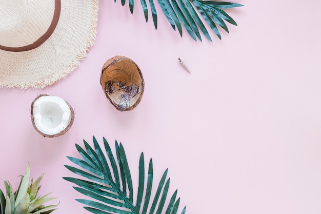 Noix de coco avec feuilles de palmier et chapeau de paille