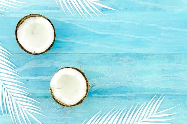 Noix de coco avec des feuilles de palmier sur une table en bois