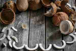 Photo gratuite noix de coco fraîches cassées sur un mur en bois