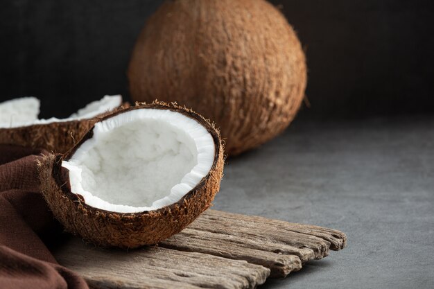 Noix de coco fraîches mises sur fond sombre