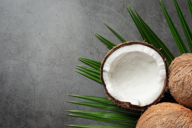 Noix de coco fraîches mises sur fond sombre