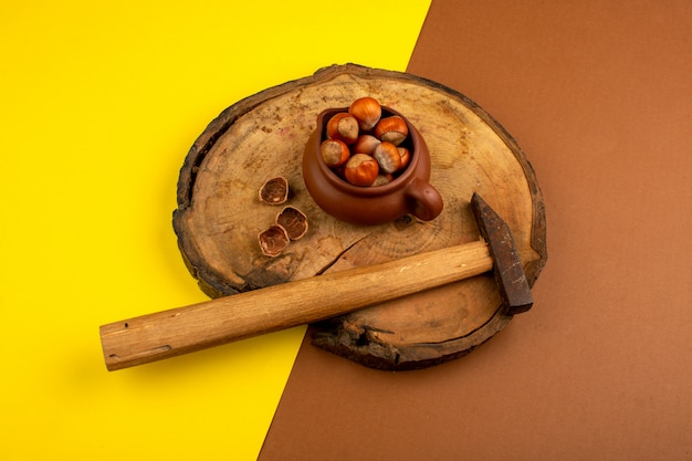 Photo gratuite noix avec marteau sur un bureau en bois et jaune-brun