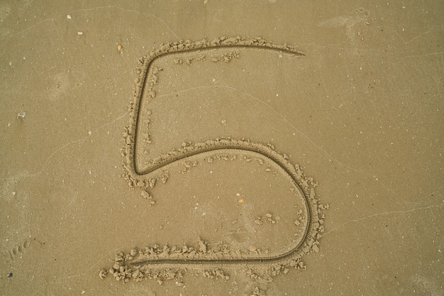 Photo gratuite nombre écrit dans le sable