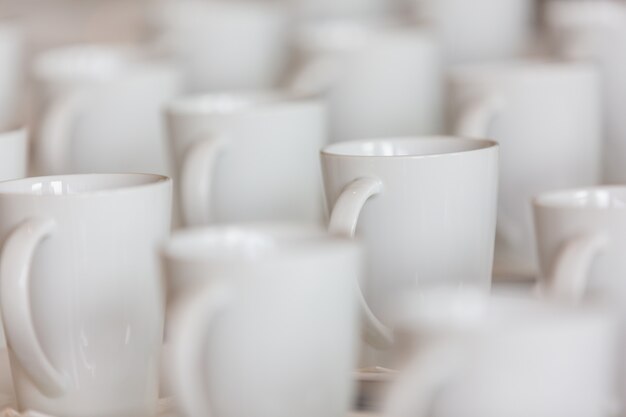 De nombreuses tasses à café blanches sont placées sur la table.