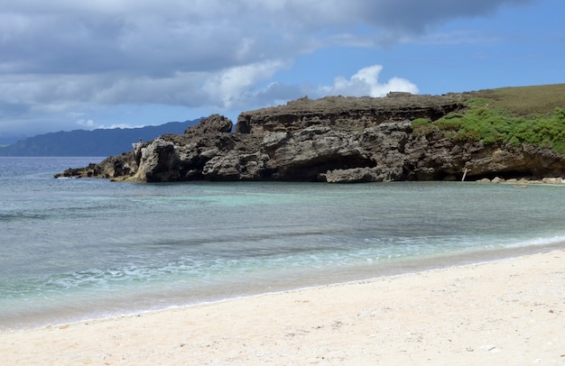 Énorme formation rocheuse près de la mer sous le ciel nuageux