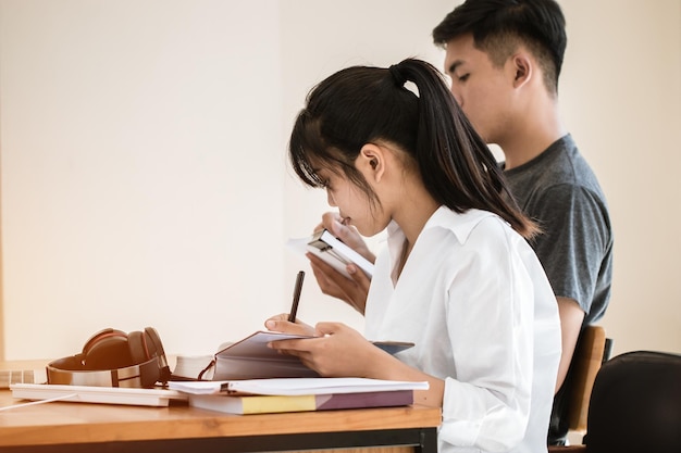 Note d'étudiant asiatique sur un cahier tout en apprenant à étudier et à écrire pour planifier le travail. étudier en éducation au concept universitaire. retour à l'école