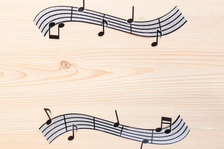 Photo gratuit notes de musique ondulées plates avec fond en bois