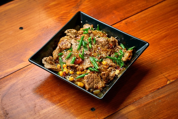 Nouilles asiatiques funchose au bœuf, légumes et sauce aigre-douce. wok de nouilles cellophane
