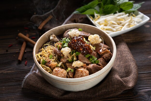 Nouilles au porc et boulettes de porc, pâte de piment avec soupe style thaï et légumes. Nouilles de bateau. Mise au point sélective