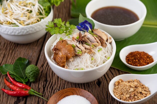 Nouilles au poulet dans un bol avec accompagnements, cuisine thaïlandaise